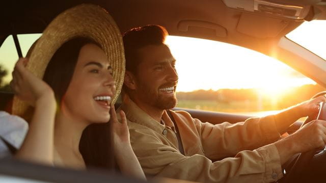 Happy couple enjoying trip together by car